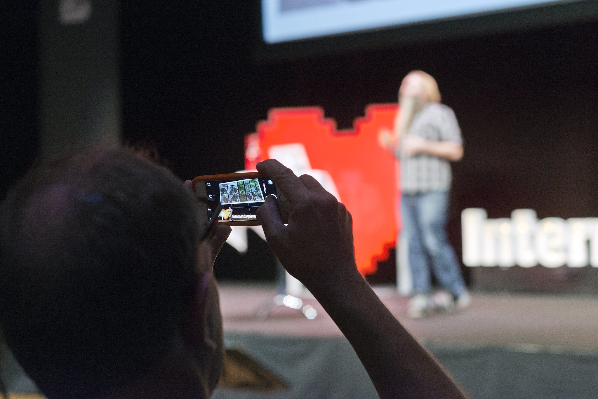 En person tar en mobilbild på en föreläsare under Internetdagarna 2015.